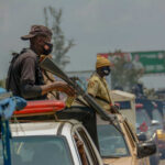 Armed security personnel on vehicles in traffic jam