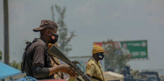 Armed security personnel on vehicles in traffic jam
