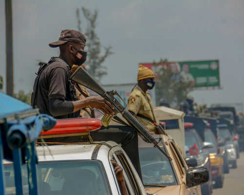 Armed security personnel on vehicles in traffic jam