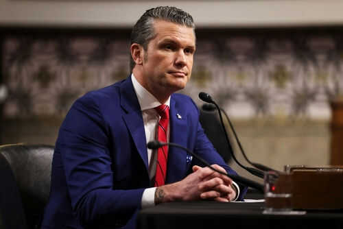 Man in blue suit speaking at a microphone