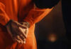 Shock Verdict: Doctor Gets 13 Months for Fatal Hit-and-Run Person in orange jumpsuit with hands cuffed behind