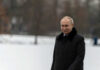 Person in dark coat standing on snowcovered ground