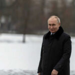 Person in dark coat standing on snowcovered ground