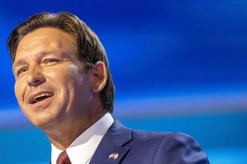 Man in a suit speaking on stage