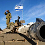 Israel’s Stunning Defense FREEDOM—No U.S. Leash! Soldier saluting from atop a tank with an Israeli flag in the background