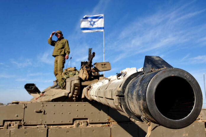 Nir,Oz,israel,-,Jan,13,2009:israeli,Soldier,Standing,On,Merkava Soldier saluting from atop a tank with an Israeli flag in the background