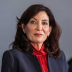 Hochul Press Office TORCHES Portnoy Online Close-up portrait of a woman in professional attire with a serious expression