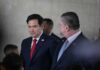 UNSTOPPABLE? Rubio’s New Route Defies Tehran A man in a blue suit speaking into a microphone with an American flag in the background