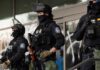 Minnesota’s Bold Move Against ICE Tactics Three police officers in riot gear standing guard outside a building