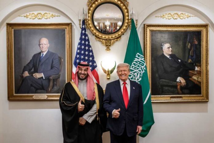 Two political leaders posing for a photo with flags in the background