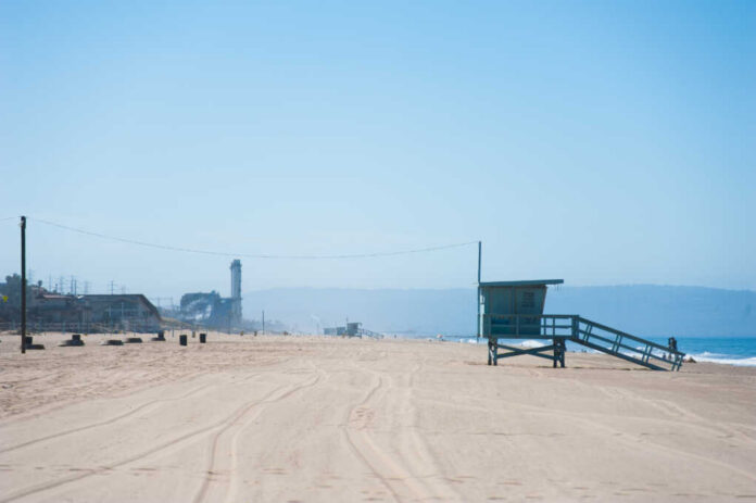 Life,Guard,Tower,At,The,Dockweiler,Beach,In,California A vibrant rainbow flag waving against a city backdrop