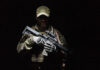 A soldier holding a rifle in a dark setting