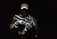 A soldier holding a rifle in a dark setting