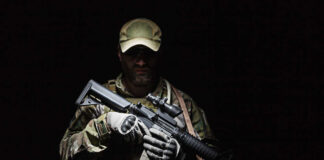 A soldier holding a rifle in a dark setting