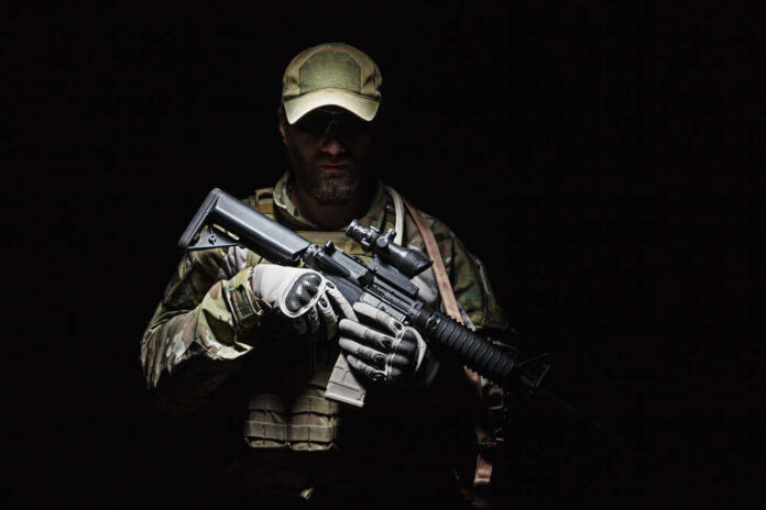 A soldier holding a rifle in a dark setting