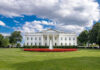 White House PANIC: Armed Suspect Breaches Checkpoint The White House with fountain and lawn under a partly cloudy sky