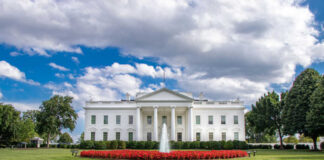 The White House with fountain and lawn under a partly cloudy sky