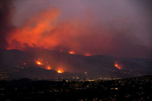 Wildfire lighting up the night sky over hills