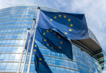 European Union flags outside modern glass building