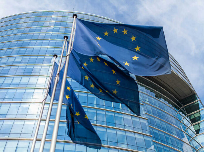 European Union flags outside modern glass building