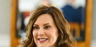Person smiling indoors with blurred background