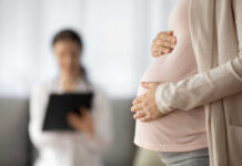 Shield Law Loophole Supercharges Abortion Pregnant person holding their belly during a medical visit