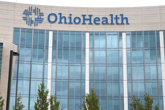 Columbus,ohio,April,30,,2019:,Ohio,Health,Is,A,Not-for-profit,System Hands of professionals discussing documents beside a judge's gavel