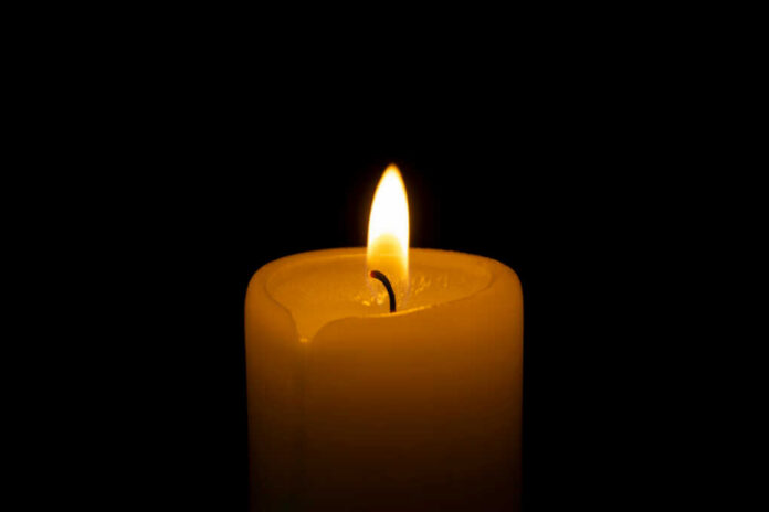 Close,Up,Of,Orange,Wax,Candle,Flame,On,A,Dark Candle flame glowing in the dark