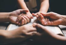 Nevada STRIPS Parents’ Right to Abortion Notice Multiple hands clasped together over an open book