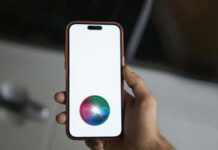 Apple Rebuilds Siri With Big Privacy Claims Hand holding smartphone with Siri logo visible