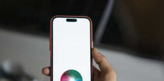 Hand holding smartphone with Siri logo visible