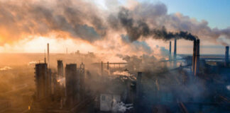 Industrial facility with smoking chimneys under a colorful sky