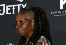 Person with dreadlocks smiling and wearing glasses.