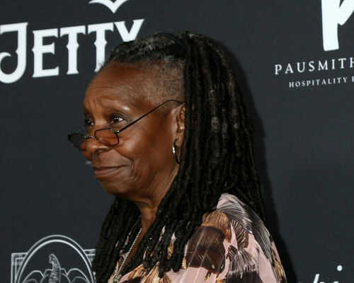 Person with dreadlocks smiling and wearing glasses.