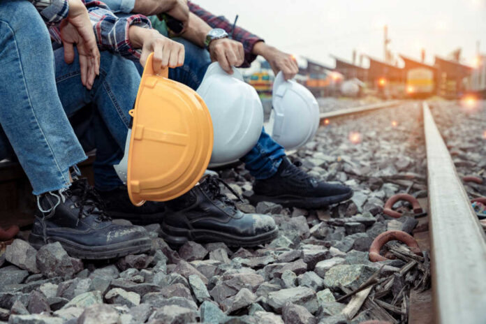 workers-holding-hard-hat-and-engineers1936021519jpg Railway workers sitting on track ballast holding hard hats