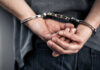 Person handcuffed with hands behind back.
