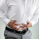 Person clutching stomach in apparent discomfort.