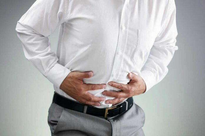 84271248 Person clutching stomach in apparent discomfort.