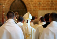 Excommunication Bombshell Rocks Vatican Loyalists Clerics in white robes facing altar in church