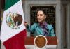 Padded Victory? Mexico’s Murder Math War Person speaking at podium with Mexican flag nearby