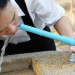 Poisoned Taps? Police Hunt Water Saboteur Person drinking water from a blue outdoor faucet