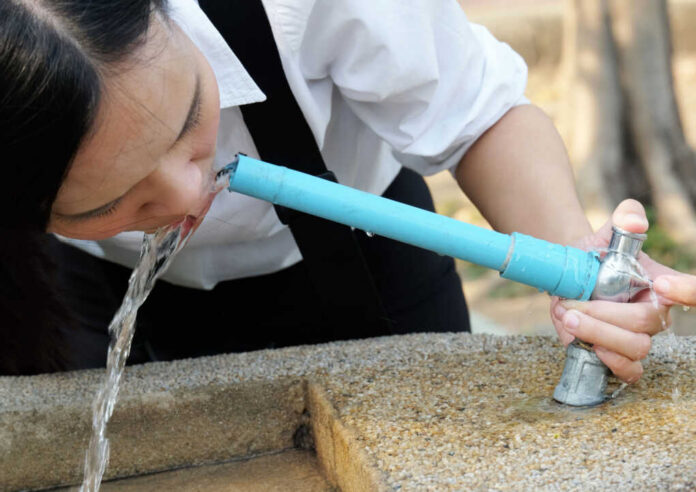 drinking-tap-water407086804jpg-3 Person drinking water from a blue outdoor faucet