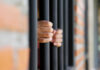 Espionage Playbook Snags American Scientist Hands gripping prison bars