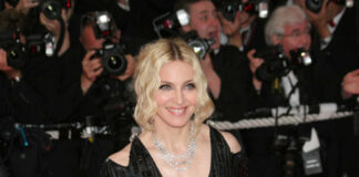 smiling woman on red carpet in black sequin dress