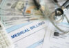 Stethoscope calculator and money on medical billing papers