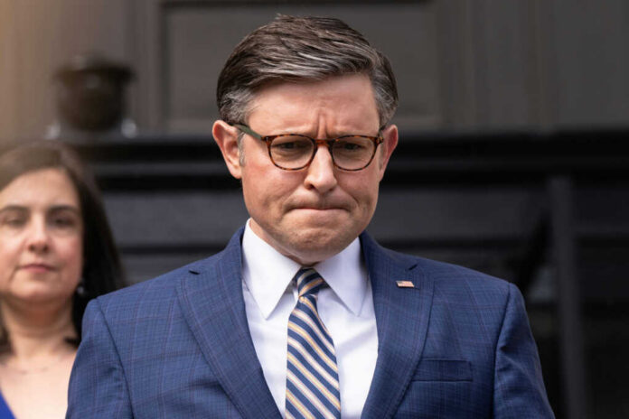 mike-johnson-arrives2453739457jpg Man in blue suit with glasses looks down thoughtfully