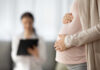 Billionaire’s Baby Factory Sparks DC Fury Pregnant person holding their belly during a medical visit