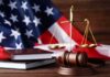 Gavel, law books, and scales with American flag background