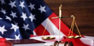 Gavel, law books, and scales with American flag background