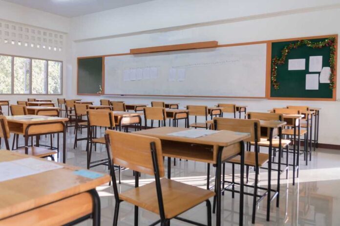 School,Empty,Classroom,With,Test,Sheet,Or,Exams,Paper,On An empty classroom with wooden desks and a chalkboard